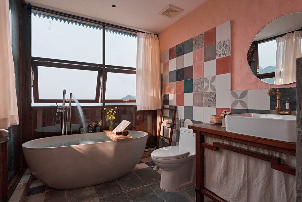 Badkamer van een bungalow bij Ha Giang Aya Lodge met vrijstaand bad en uitzicht over de bergen van Ha Giang