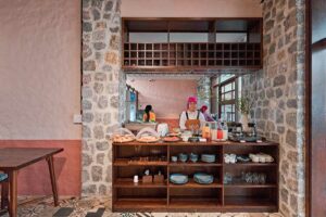 Hmong medewerker bereidt ontbijt in het restaurant van Ha Giang Aya Lodge met lokale producten en drankjes