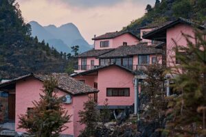 Exterieur van Ha Giang Aya Lodge in de bergen van Noord-Vietnam met traditionele architectuur tussen het karstlandschap