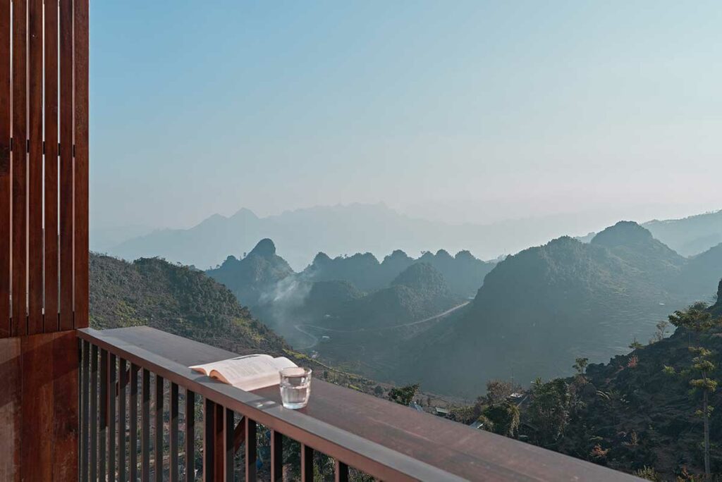 Balkon van een kamer bij Ha Giang Aya Lodge met uitzicht over het karstlandschap en de bergen van Ha Giang