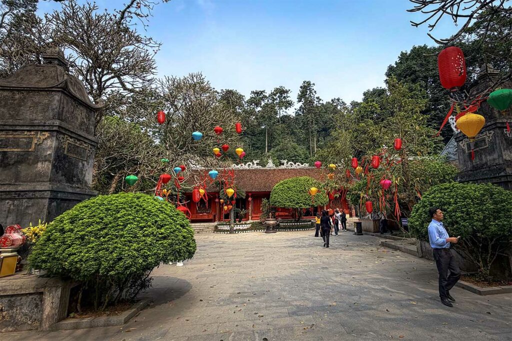 Ha Tempel (Lower Temple) in het Hung Kings complex versierd met kleurrijke lantaarns en bezoekers op de binnenplaats.
