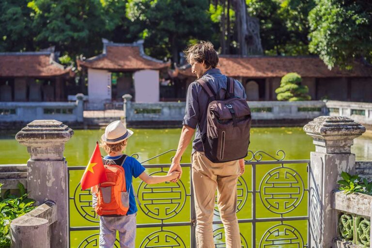 Hanoi met kinderen bij de Tempel van Literatuur met vijver en traditionele Vietnamese architectuur