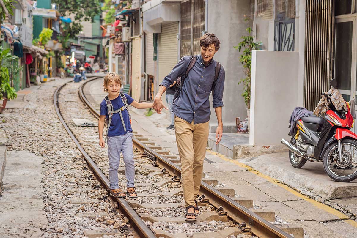 Hanoi met kinderen wandelend over de bekende Train Street tussen huizen en spoorrails