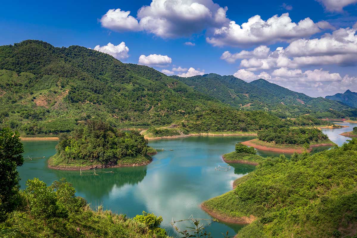 Groen landschap van Hoa Binh Lake in Noord Vietnam met kronkelend water tussen beboste bergen