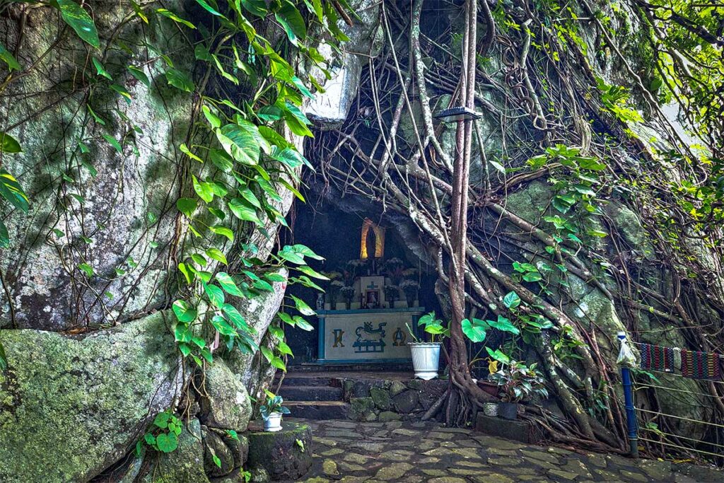 Maria grot in Con Dao National Park, een kleine junglegrot met altaar omringd door rotsen en boomwortels langs een wandelroute