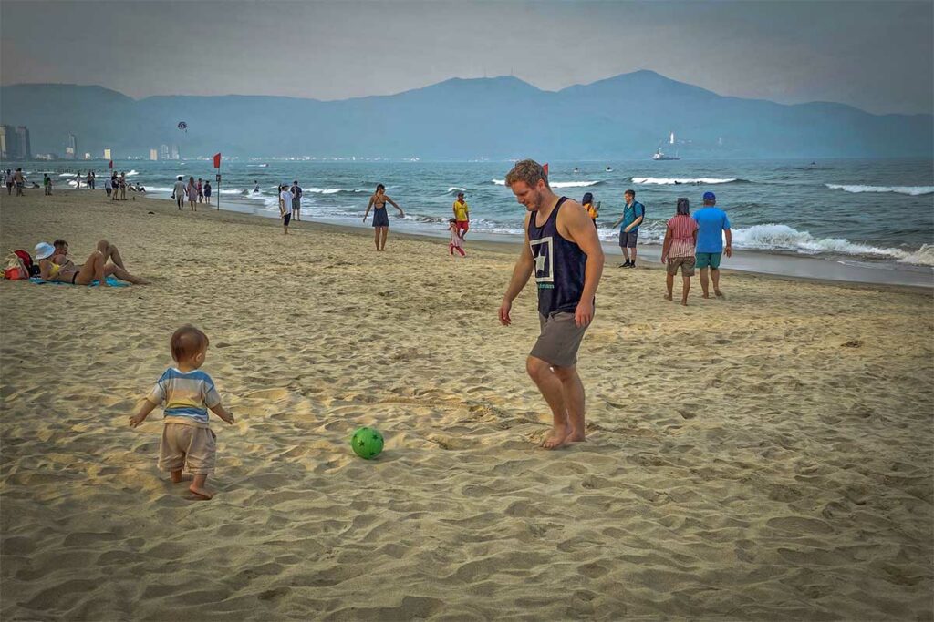 Marnick Schoonderwoerd speelt met zijn zoon op het strand van Da Nang tijdens hun leven in Vietnam