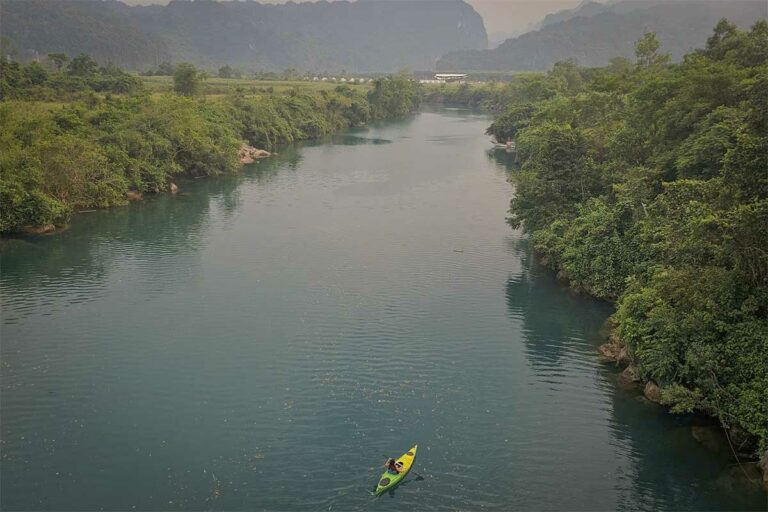 Nhung Phung van het Local Vietnam team tijdens kajakken op de rivier in Phong Nha-Ke Bang National Park in centraal Vietnam