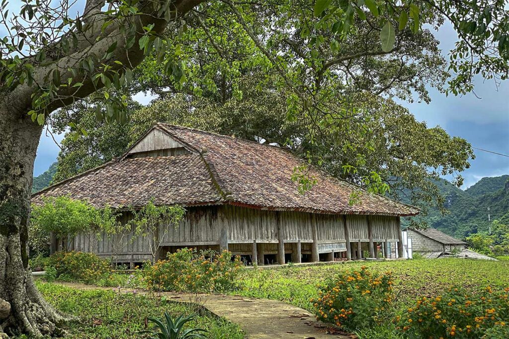Traditioneel houten Nong Luc communal house in Bac Son Valley omgeven door groen en bergen