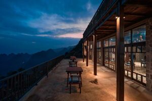 Terras van het restaurant bij Ha Giang Aya Lodge met uitzicht over de bergen van Ha Giang tijdens zonsondergang