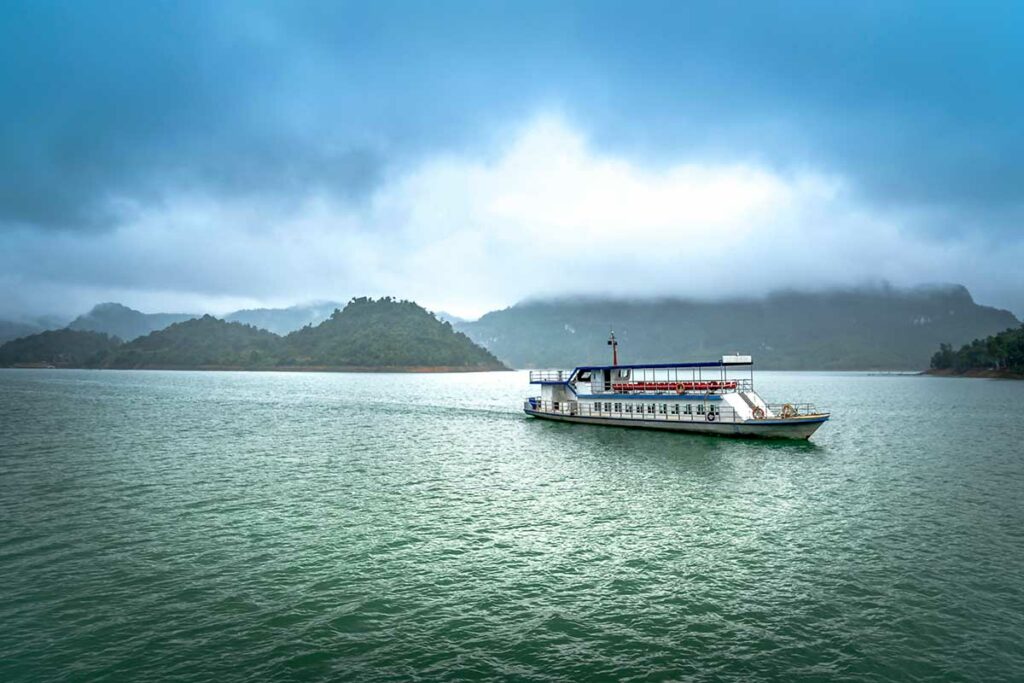 Boot op Thac Bo Lake in Hoa Binh Vietnam met mistige bergen en rustig water