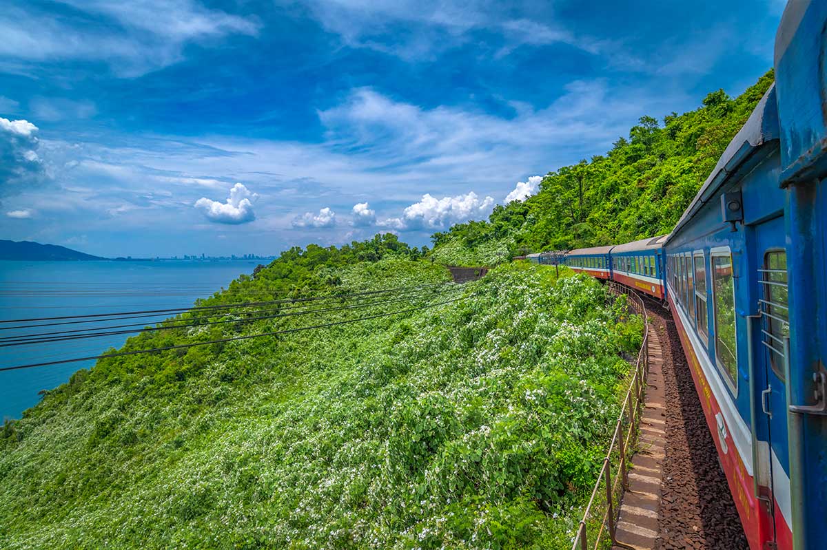 Trein langs de Hai Van Pass tussen Hue en Da Nang met uitzicht op zee en groene bergen in Vietnam