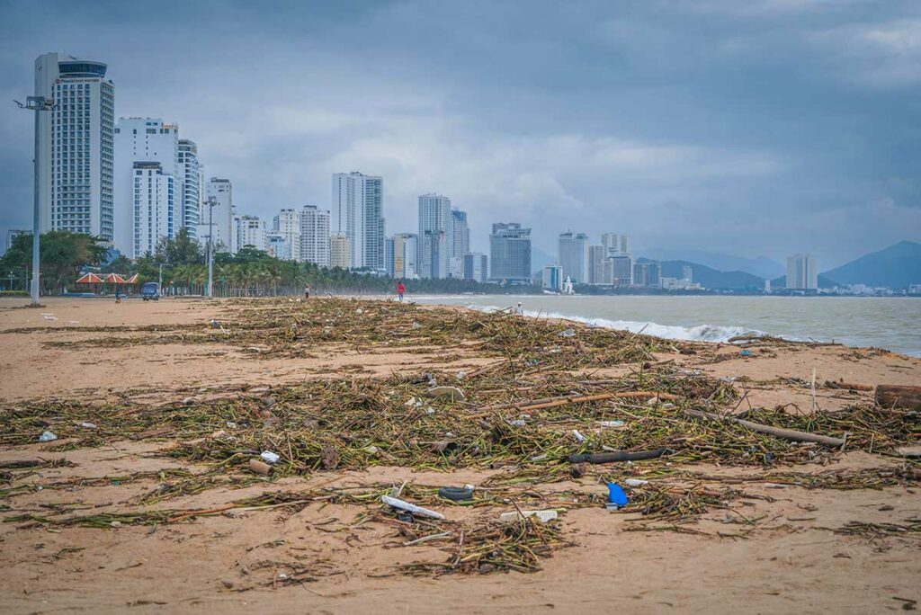 Strand in centraal Vietnam bedekt met aangespoeld afval en takken na een tyfoon