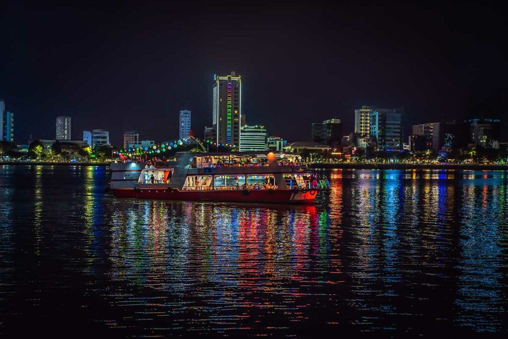 Avondcruise op de Han River in Da Nang met verlichte boot en skyline, een populaire manier om de Dragon Bridge en vuurshow vanaf het water te bekijken.
