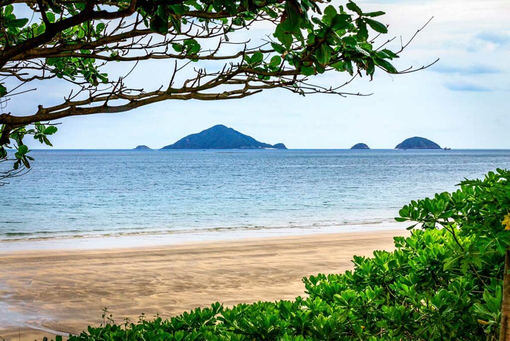 Lang en rustig strand van Dat Doc Beach in Con Dao met helder water en een afgelegen baai omringd door natuur.