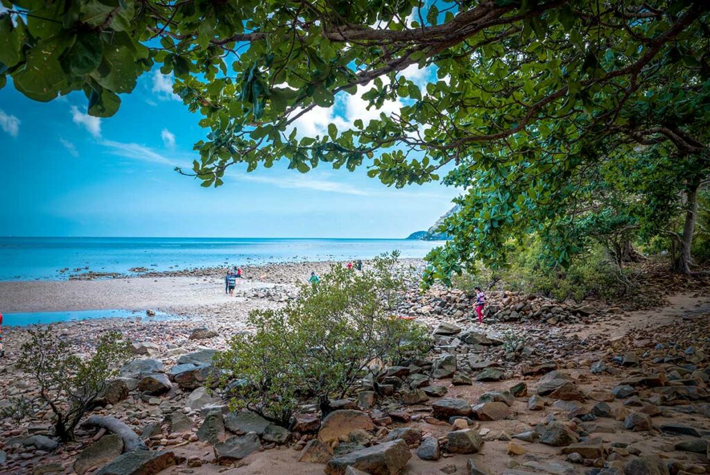 Rotsachtig strand en kustlijn in Con Dao National Park met wandelaars langs de zee