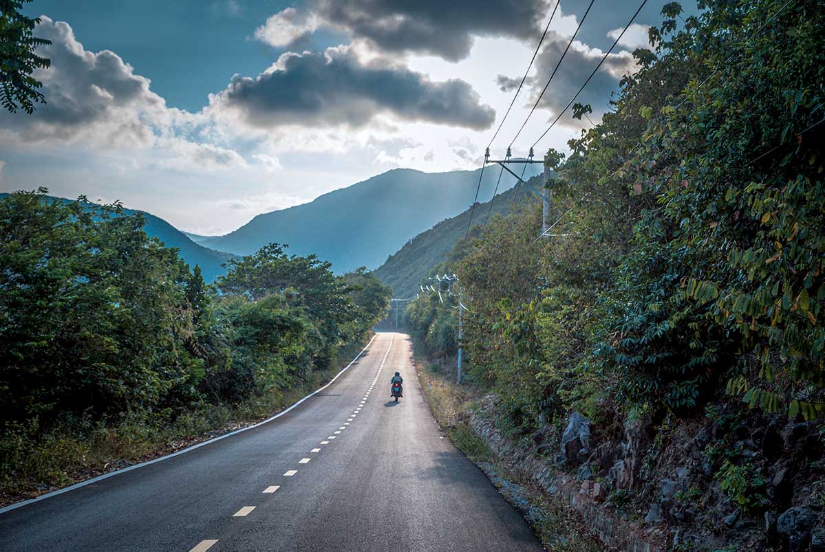 Weg door het bergachtige landschap van Con Dao National Park met motorbike tussen jungle en heuvels
