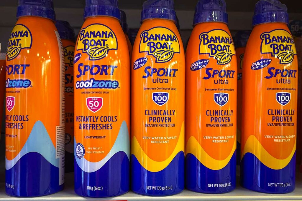 Banana Boat Sport sunscreen spray cans with SPF 50+ and SPF 100 on a shop shelf in Vietnam