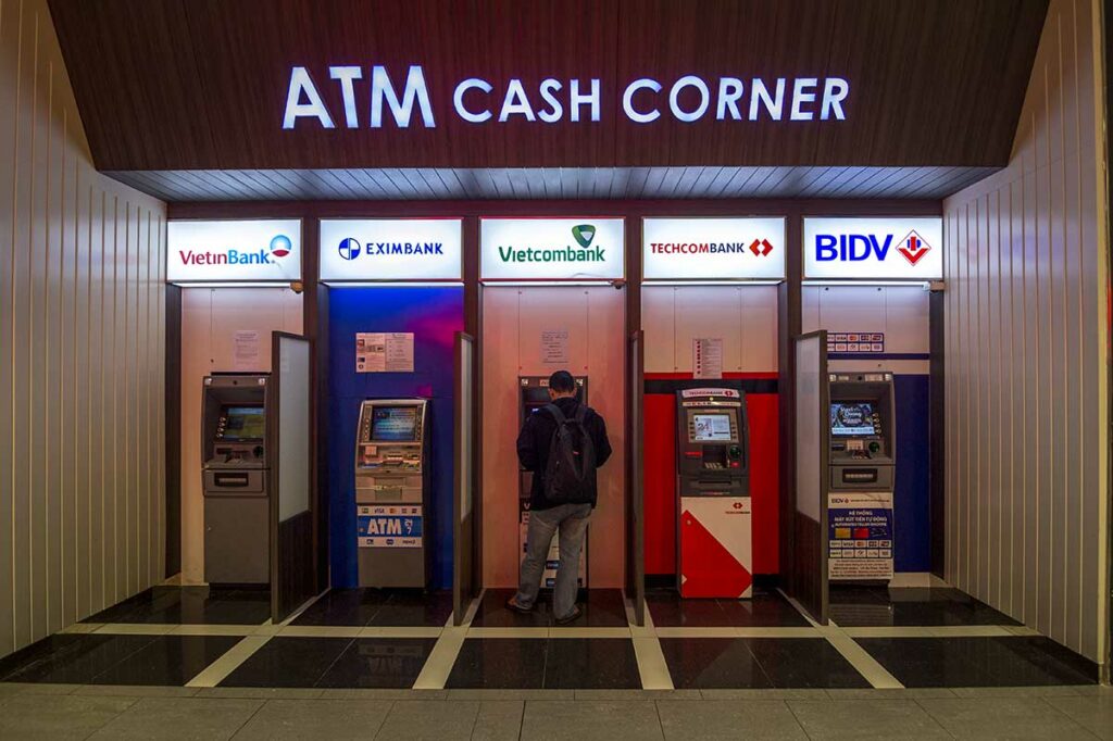 Rij geldautomaten van Vietnamese banken waaronder Vietcombank, Techcombank en BIDV in een ATM Cash Corner, waar reizigers met Wise of een andere buitenlandse kaart Vietnamese dong kunnen opnemen