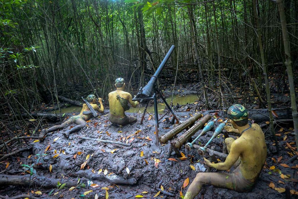 Wassenbeelden van Vietcong-guerrillastrijders in de modder van het Sac bos in het Can Gio reservaat, met een mortierstelling en munitie tussen de mangrovewortelswortels — een van de reconstructies die de levensomstandigheden van de guerrilla tijdens de Vietnamoorlog tonen