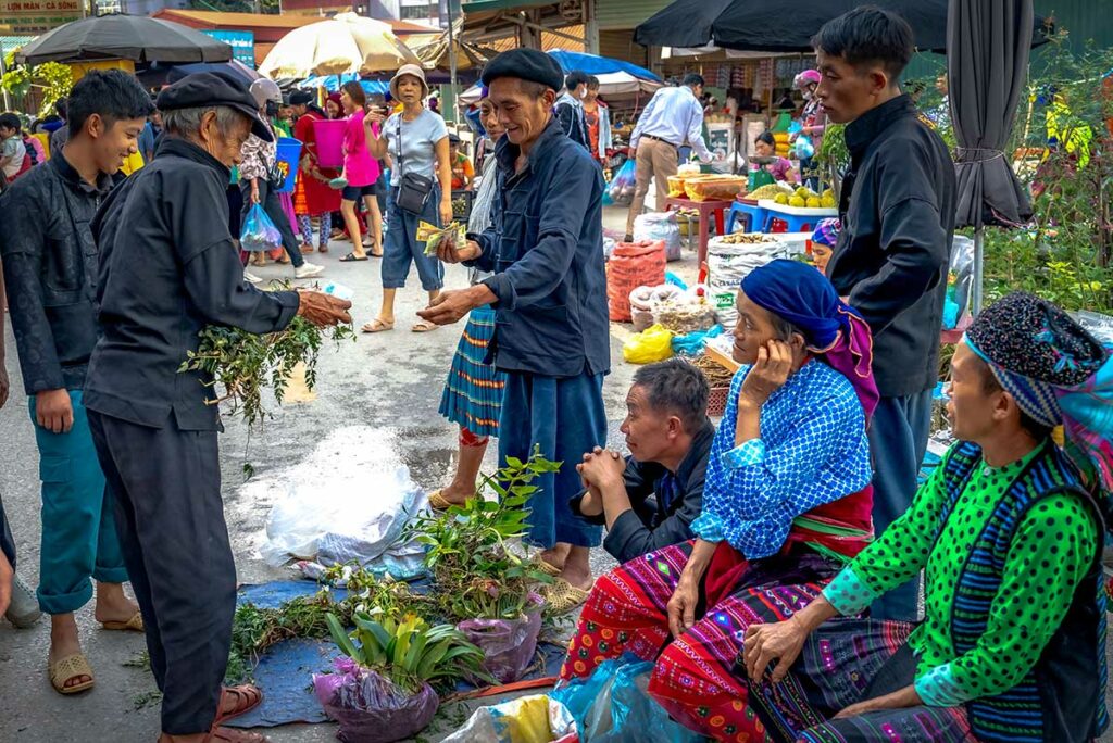 Mensen van etnische minderheden in traditionele kledij op een lokale markt in Ha Giang, het respecteren van lokale culturen is een kernonderdeel van verantwoord reizen in Noord-Vietnam