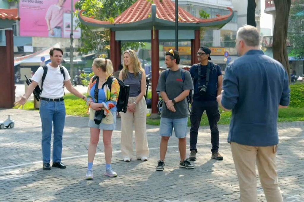 resentator Tijl Beckand brieft vijf deelnemers van Het Perfecte Plaatje op Reis op een plein in Ho Chi Minh City, Vietnam