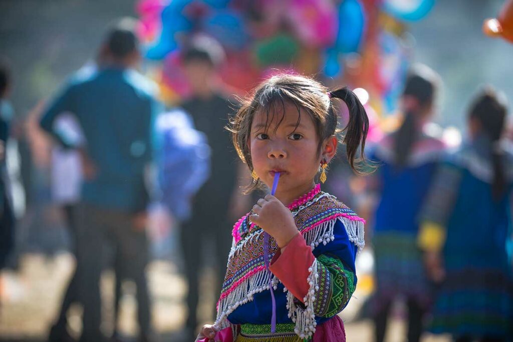 Jong meisje in traditionele Hmong-kledij in Noord-Vietnam, een voorbeeld van waarom verantwoorde reizigers in Vietnam geen snoep of geld geven aan kinderen op straat