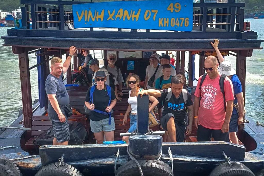 Groep duikers en reizigers stapt van een houten boot in Nha Trang — Sailing Club Divers is een van de bekendste duikcentra in Nha Trang en organiseert dagelijkse boottochten naar de eilanden