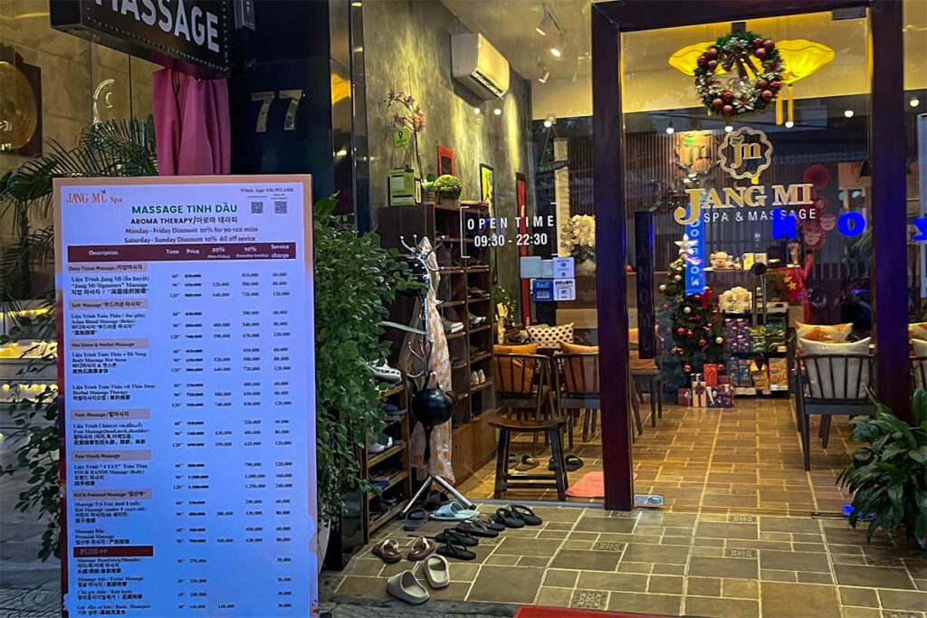 Gedetailleerde menukaart met massageprijzen in Vietnamese dong buiten een massagesalon in Vietnam, met behandelingen zoals deep tissue, hot stone en voetmassage