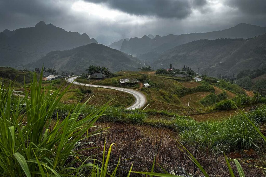 Bochtige weg over de Na Tenh pas in Cao Bang onder een donkere, bewolkte lucht