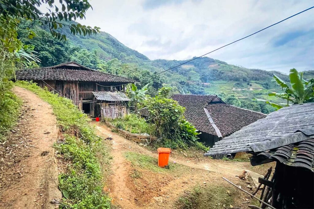Houten huizen met tegeldaken langs een zandpad in het bergdorp Khuoi Khon bij Bao Lac, Cao Bang