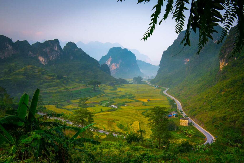 Groene vallei met rijstvelden en een kronkelende weg gezien vanaf de Ma Phuc pas in Cao Bang