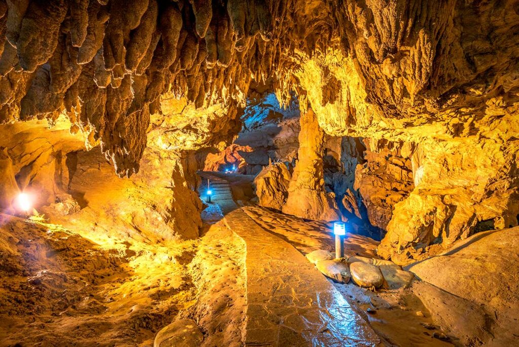 Verlicht wandelpad door de Nguom Ngao grot in Cao Bang, met stalactieten aan het plafond