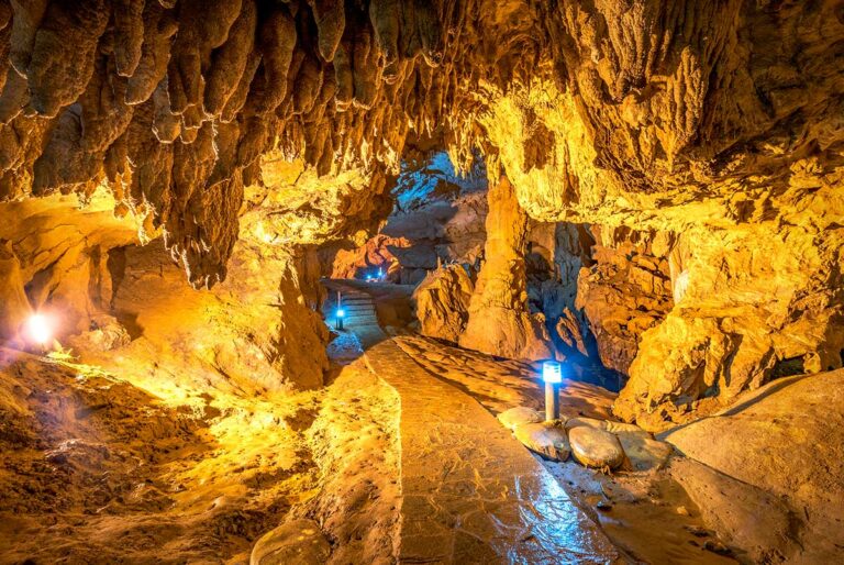 Verlicht wandelpad door de Nguom Ngao grot in Cao Bang, met stalactieten aan het plafond