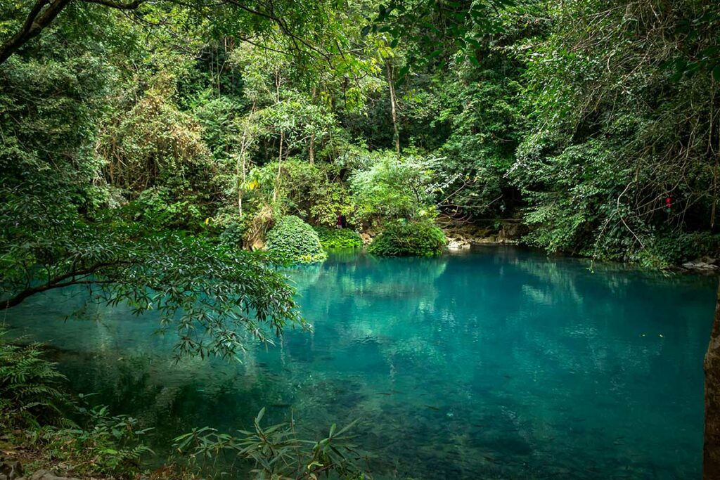 Helderblauw water van de Le Nin rivier tussen het groen bij Pac Bo in Cao Bang