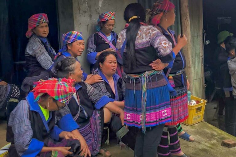 Groep vrouwen in traditionele kleding bij elkaar in een dorp in Mu Cang Chai, Yen Bai