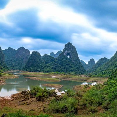 Angel Eye Mountain in Cao Bang gezien vanaf de vallei, met het natuurlijke gat duidelijk zichtbaar tussen de groene karstbergen.