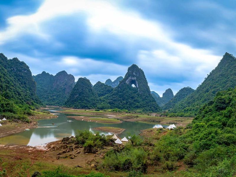 Angel Eye Mountain in Cao Bang gezien vanaf de vallei, met het natuurlijke gat duidelijk zichtbaar tussen de groene karstbergen.