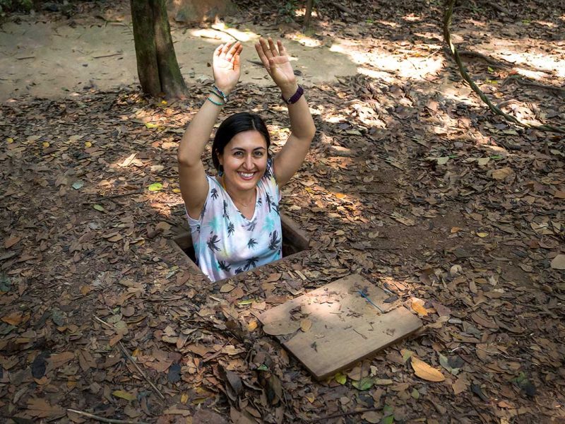 Bezoeker kruipt uit een verborgen tunnelopening bij de Cu Chi Tunnels, gebruikt door Viet Cong-strijders tijdens de Vietnamoorlog