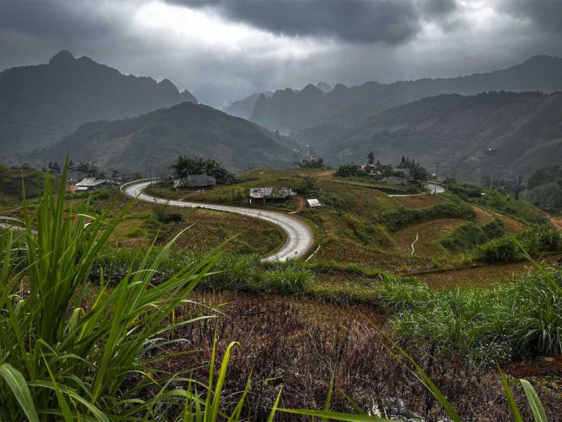 Bochtige weg over de Na Tenh pas in Cao Bang onder een donkere, bewolkte lucht