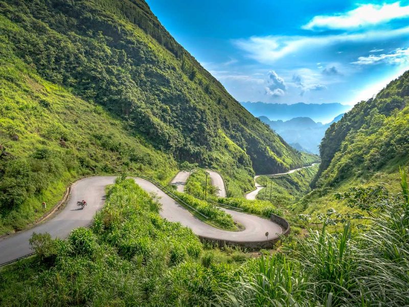 Bergpas met scherpe haarspeldbochten in Ha Giang, een populaire locatie voor landschaps- en motorreisfotografie in Noord-Vietnam.