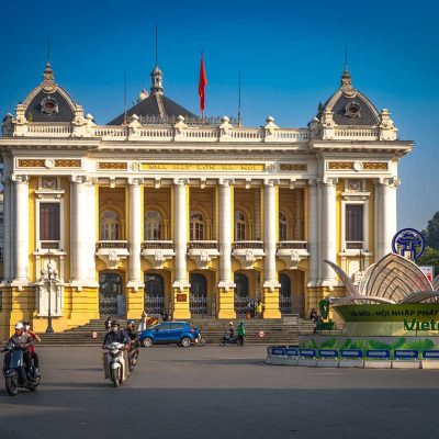 Hanoi Opera House gezien vanaf straatniveau in de Franse wijk, met verkeer en koloniale architectuur