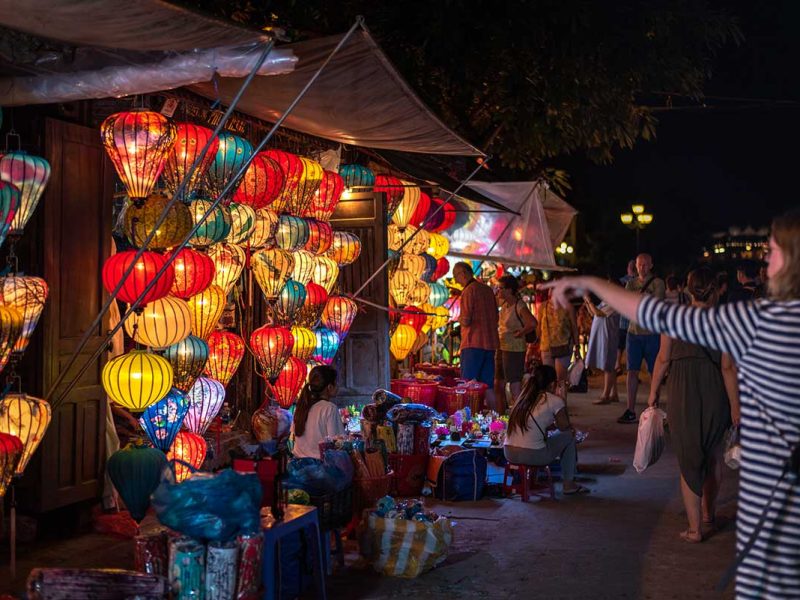 Avondsfeer op de Hoi An nachtmarkt, met kraampjes, bezoekers en kleurrijke verlichting langs de straten van de oude stad