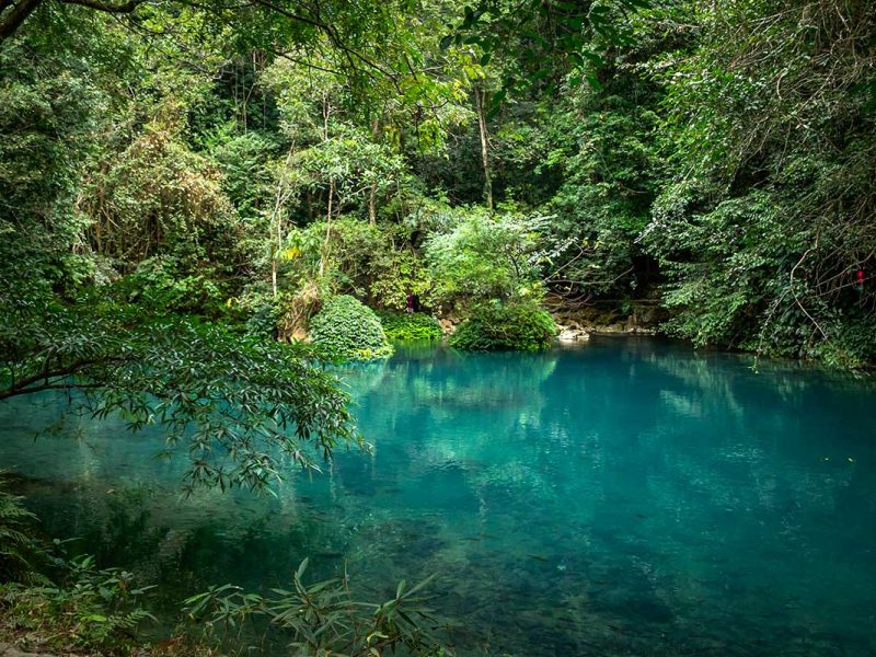 Helderblauw water van de Le Nin rivier tussen het groen bij Pac Bo in Cao Bang