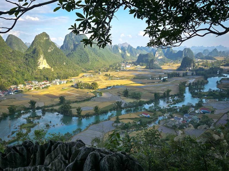 Uitzicht vanaf het Phong Nam Valley viewpoint over rivier, rijstvelden en karstbergen in Cao Bang tijdens helder weer