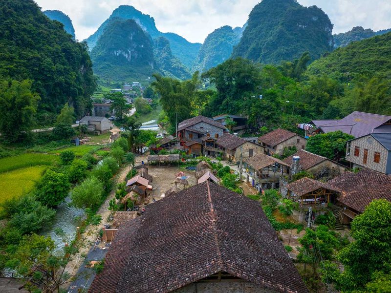 Luchtfoto van het stenen dorp Khuoi Ky bij Trung Khanh, met tegeldaken tussen rijstvelden en kalksteenbergen